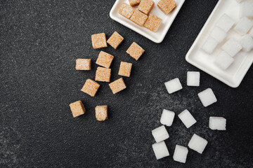 Sugar cubes in various types on a dark surface for contrast