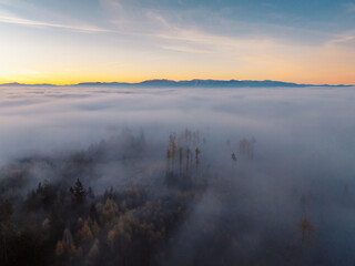 Obraz premium Misty morning in Liptov region with High Tatras mountains around. Liptovsky Mikulas landspace, slovakia.