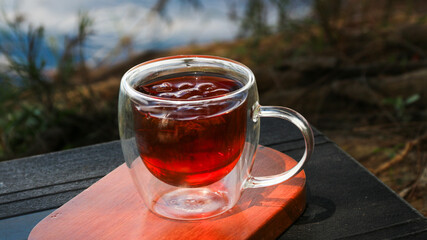 A cup of iced tea and aromatics with a blurred natural garden background