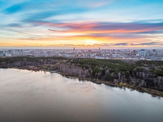 Obraz premium Colorful autumn forest with trees on the shore of a blue lake - top aerial view.