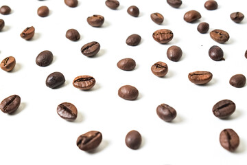 Obraz premium Close up view of roasted coffee beans isolated on white background. Texture, detail, scattered.