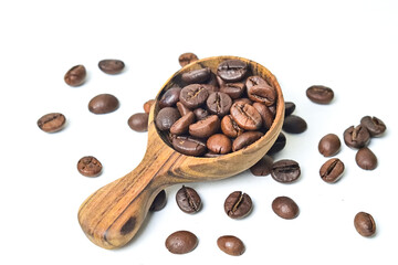 Fototapeta premium Close up view of roasted coffee beans in little wooden spoon. isolated on white background. Clipping path. Scattered. Cut out.