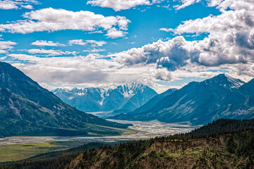 Fototapeta premium The Slims River flows below the snowy mountains viewed from Sheep Creek Trail at Kluane National Park, Yukon, Canada