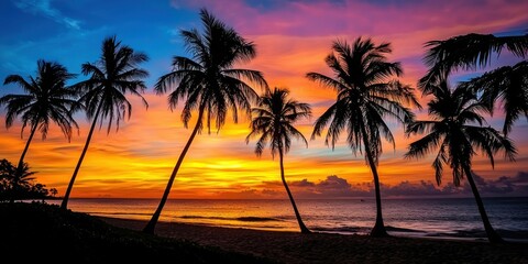 A tropical beach with tall palm trees silhouetted against a glowing sunset sky