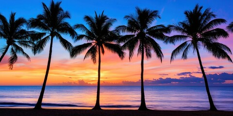 A tropical beach with tall palm trees silhouetted against a glowing sunset sky