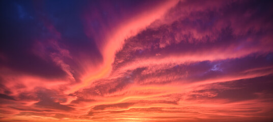 Fototapeta premium Purple red and blue vivid sunset sky with sweeping cloud lines at golden hour, dramatic backdrop for travel mood nature and weather visuals