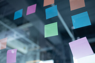 Reminder paper note on glass surface in office. Paper sticky notice post.