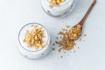 Yogurt parfait with granola and blueberries in glass cups