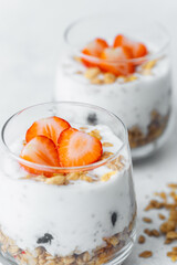 Yogurt parfaits topped with sliced strawberries and granola