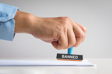 Male hand holding a banned rubber stamp. 