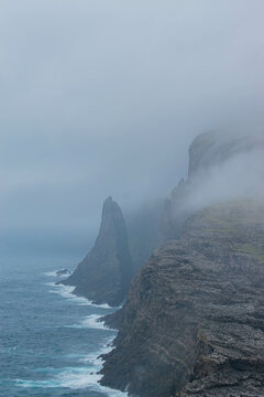 Traelanipa waterrfall on Vagar island, Faroe Islands, mountain ocean landscape, durring foggy day
