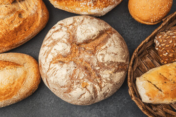 Freshly baked artisan breads laid out on a dark countertop