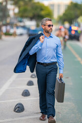 Businessman walk to work. Hispanic businessman walking on the street confidently. Office worker on way to office. Middle-aged businessman walking on city. Businessman in a summer outfit walking.