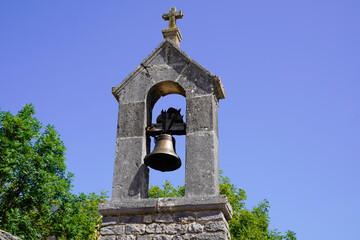 traditional french bell on the roof of church chapel in the south of France in middle of blue...