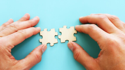 Male hand holding puzzle pieces. Concept of strategy and success