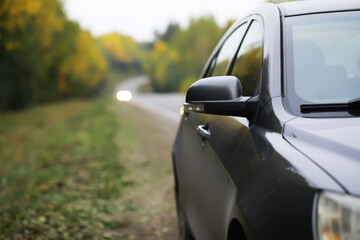 Close-Up of Black Car's Side Mirror on Countryside Road During Fall Season