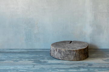 Atmospheric art background of plastered grey blue wall and empty shabby round wooden stand, copy space.