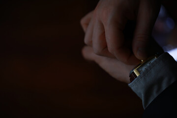 Close-Up of Businessman Adjusting His Wristwatch in Low Light Setting
