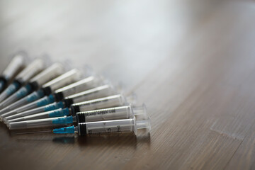 Row of Medical Syringes on Wooden Surface Highlighting Healthcare and Vaccination Concept