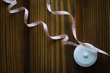 Curled Measuring Tape on Wooden Surface for Sewing and Craft Projects