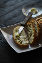 Rustic Bread Slices with Butter and Knife on White Plate