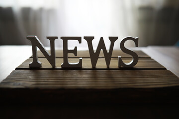 Wooden Block Letters Spelling NEWS on Rustic Wooden Table Background