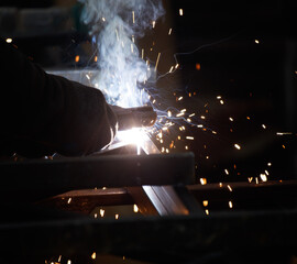 A man is welding metal with sparks flying