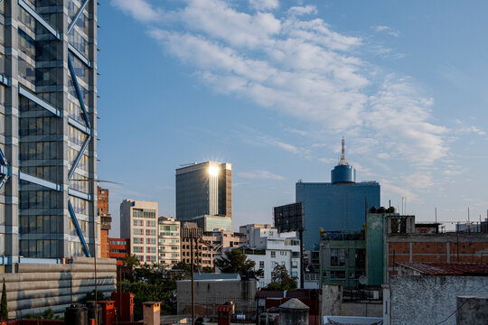 Urban skyline in Mexico City with glass facades, modern architecture, and clear blue sky, ideal for business, cityscape, and real estate development imagery.