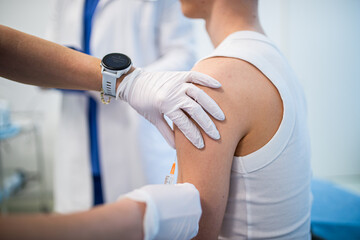 Teenage boy receiving vaccination during routine health checkup.