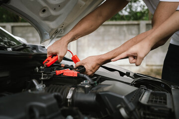 Man inspecting damaged car after crash, documenting insurance claim with mobile phone, showing...