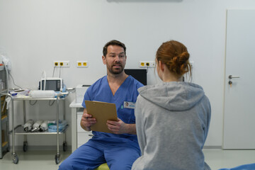 Teenage girl confiding in doctor about personal and health problems.