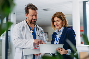Female medical sales representative presenting medication to doctor