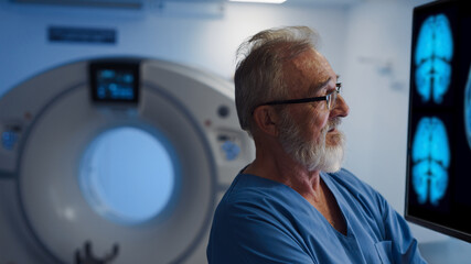 Fototapeta premium Portrait of doctor looking at CT scans of brain.