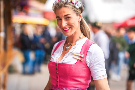 Bayerin in Dirndl laechelt in die Kamera vor festlicher Kulisse. Oktoberfest M&uuml;nchen G&auml;ubodenvolksfest Straubing Maidult Regensburg Deutschland
