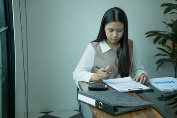 Naklejka premium Asian businesswoman working alone in office