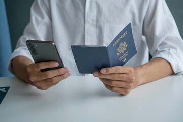Man holding passport in hand and booking ticket on phone