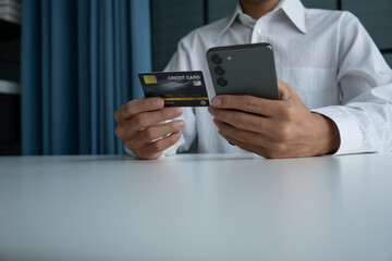 Man holding credit card and phone to pay online