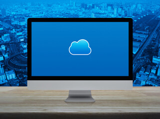 Cloud computing icon on modern computer monitor screen on wooden table over city tower, street, expressway and skyscraper, Technology cloud computing concept
