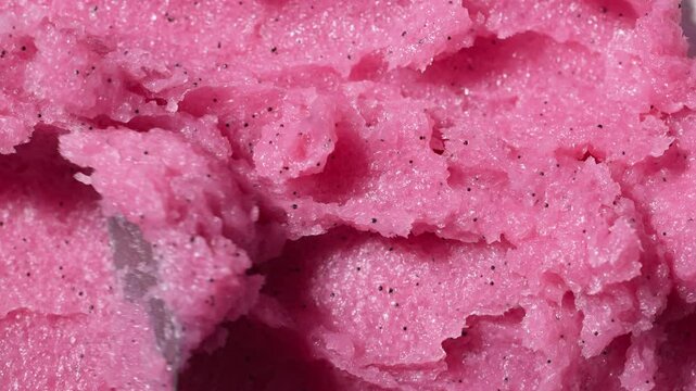 Texture of pink raspberry scrub. Fruit exfoliation scrubber for body and face in SPA. Body care scrub background for design.