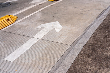 Arrow painted on sidewalk in modern cityscape, clean lines, contrast and urban geometry for design, background visuals and architecture stock applications.