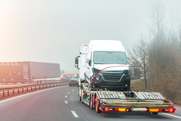 Emergency tow truck recovering damaged automobile