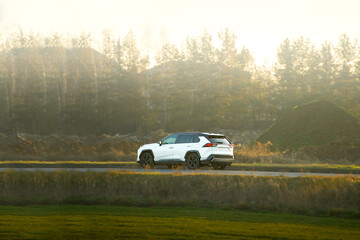 Fototapeta premium SUV driving on a sunny country road