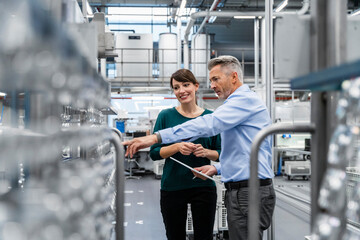 Businessman working with coworker at automated industry