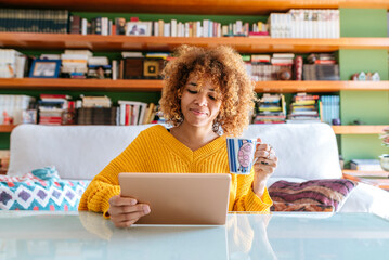 Smiling woman with tablet and cup in home