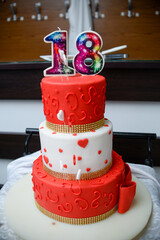 September 24, 2022 - Belgrade, Serbia. Red and white birthday cake with the emblem of the Red Star football club and the female name Nancy as well as a candle on top of the shape of the number eightee