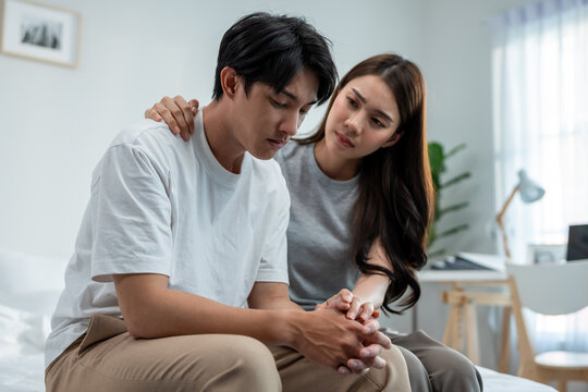 Asian wife comforting her husband crying with tears for life problem. 