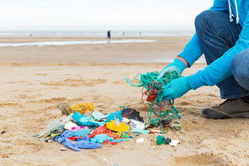Man collecting ocean waste during a beach cleanup on the North Sea coast