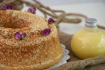 Elegant Lavender Bundt Cake with Glaze lightly dusted with powdered sugar and drizzled with a delicate white glaze and sesame seeds isolated on napkin closeup side view of unique dessert