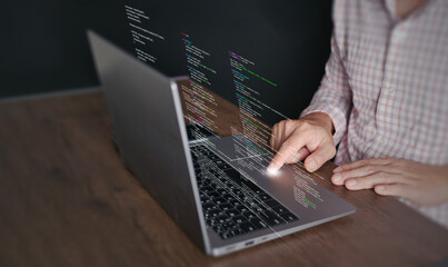 Hands of a programmer types on a laptop displaying programming code, symbolizing coding tech, software development, web applications. IT solutions, and digital technology