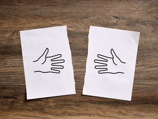 Two hands drawn on torn pieces of paper representing broken friendship